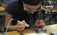 Laura D’Aquila solders her mini-car together.