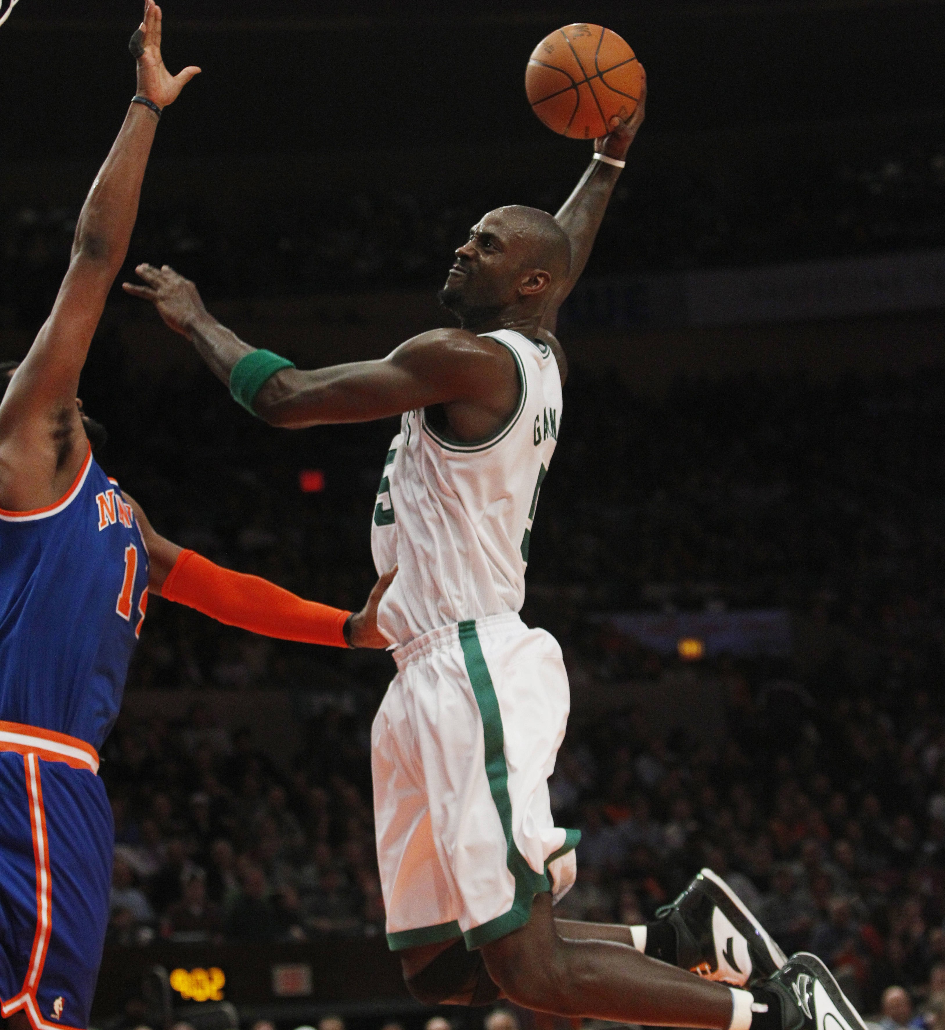 Boston Celtics' Kevin Garnett (5) dunks the ball on New York Knicks' Ronny Turiaf during the second half of an NBA basketball game Monday, March 21, 2011, in New York. The Celtics won the game 96-86. (AP Photo/Frank Franklin II)