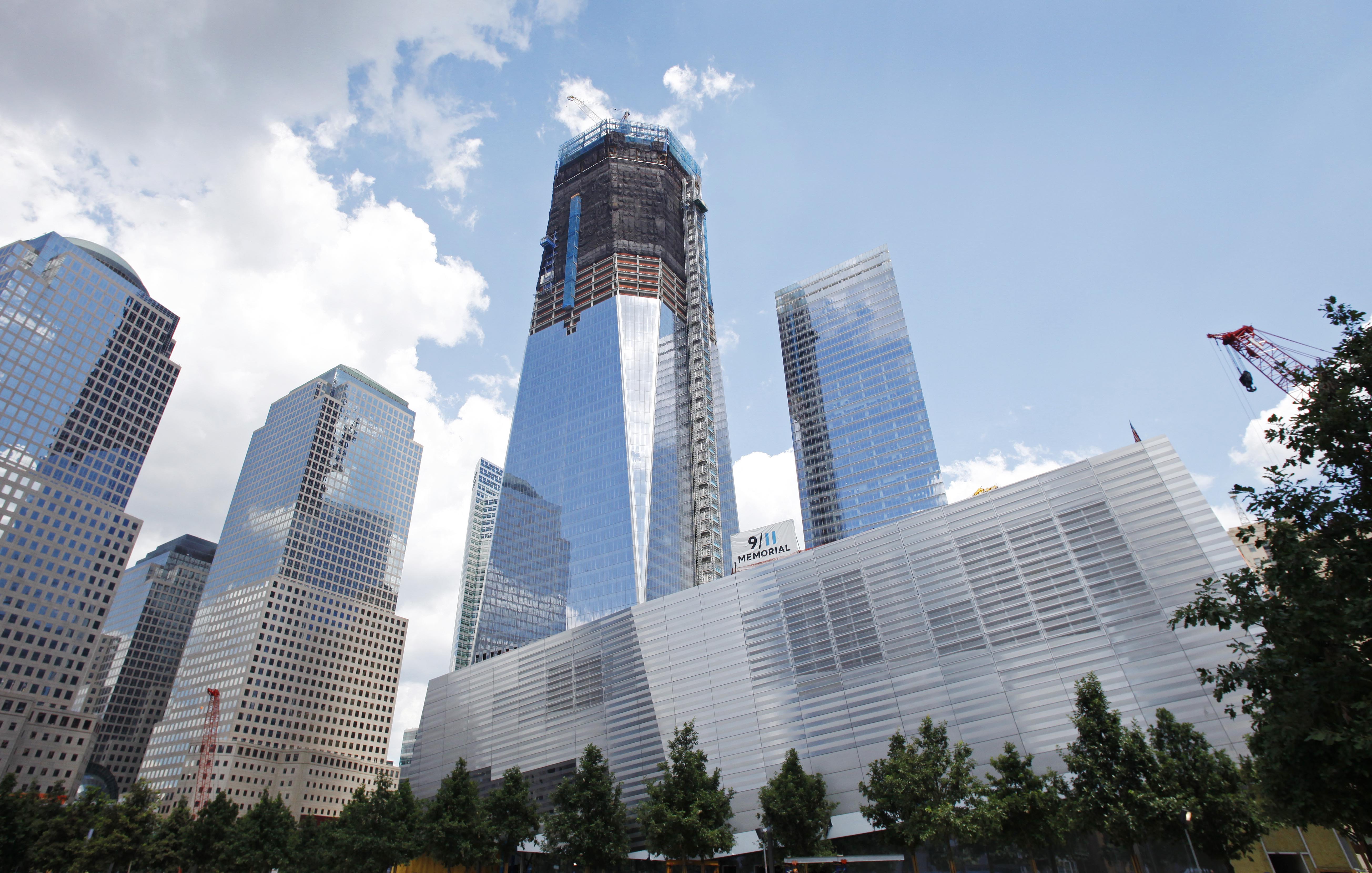 Work continues on the National September 11 Memorial at the World Trade Center site, Friday, July 15, 2011 in New York.  The memorial will be dedicated in a ceremony on September 11, 2011, the tenth anniversary of the terrorist attacks. One World Trade Center, center, rises above the site. (AP Photo/Mark Lennihan)