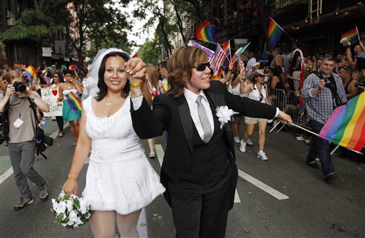 Paola Perez, left, and her partner Linda Collazo, dressed as bride and groom, march in the annual Gay Pride parade in Greenwich Village, Sunday, June 26, 2011 in New York. One of the world's oldest and largest gay pride parades was expected to become a victory celebration Sunday after New York's historic decision to legalize same-sex marriage.  The law signed by Gov. Andrew Cuomo on Friday doesn't take effect for 30 days. (AP Photo/Mark Lennihan)