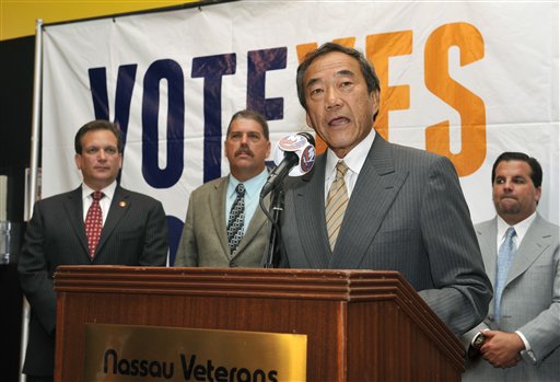 Nassau County Executive Edward Mangano, background left, listens as New York Islanders owner Charles Wang speaks at a news conference after Nassau County residents rejected a referendum to borrow $400 million for the construction of a new hockey arena and ballpark, on Monday, Aug. 31, 2011 in Uniondale, N.Y. (AP Photo/Kathy Kmonicek)