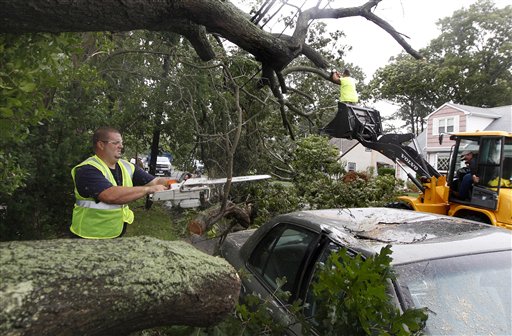 Workers clear trees that fell on power lines and cars after the effects of Hurricane Irene in Amityville, N.Y., on Long Island, Sunday, Aug. 28, 2011. (AP Photo/Charles Krupa)