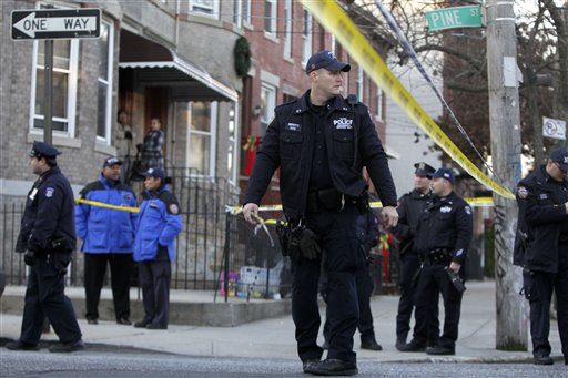 Police officers stand near a crime scene where a police officer was shot in the Cypress Hills section of the Brooklyn borough of New York, Monday, Dec. 12, 2011. Officials say the officer later died after he was shot in the face while responding to a break-in at a Brooklyn apartment. (AP Photo/Seth Wenig)