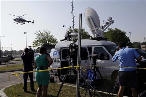 Reporters watch as police helicopter lands at the scene of a news conference as part of an investigation into a fatal boating accident in Oyster Bay, N.Y., Thursday, July 5, 2012. Police say three bodies pulled out of New York's Long Island Sound after a yacht capsized on the Fourth of July were all children. The bodies of the 12-year-old boy and two girls, ages 11 and 8, were recovered from the boat's cabin. Twenty-four other people were rescued, and were treated and released. (AP Photo/Seth Wenig)