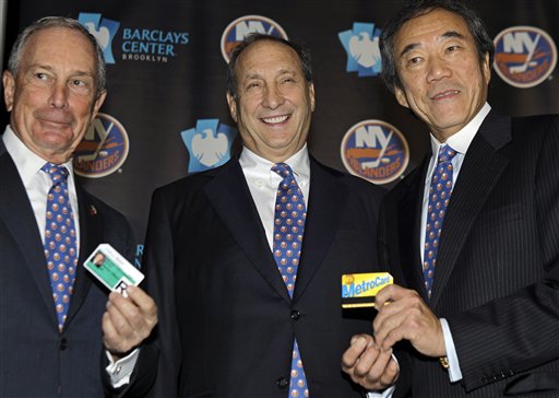 New York Mayor Michael Bloomberg, left, New York Islanders owner Charles Wang, right, pose with Barclays Center owner and developer Bruce Ratner, center, while holding mass transit fare cards during a press conference, Wednesday, Oct. 24, 2012 in New York, announcing that the Islanders hockey club will move from Nassau Veterans Memorial Coliseum in Uniondale, N.Y., and play at Brooklyn's Barclays Center starting in 2015. (AP Photo/Kathy Willens)
