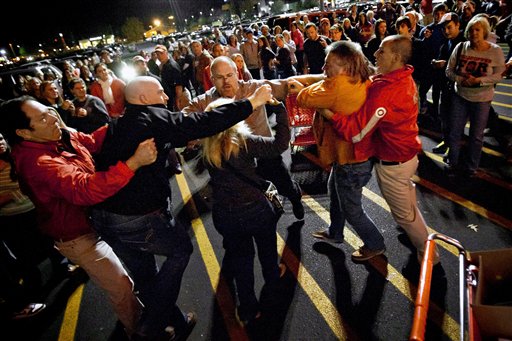 A crowd gathers as security guards break up a fight between shoppers waiting in line just as the doors open for Black Friday shopping at Target, Thursday, Nov. 22, 2012, in Bowling Green, Ky. Despite a surge of resistance as the sales drew near, with scolding editorials and protests by retail employees and reminders of frantic tramplings past, Black Friday's grip on America may be stronger than ever.  (AP Photo/Daily News, Alex Slitz)
