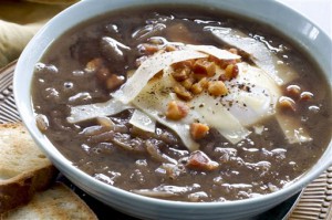 In this image taken on Dec. 20, 2012, Italian-style onion soup topped with a poached egg is shown served in a bowl in Concord, N.H. (AP Photo/Matthew Mead)