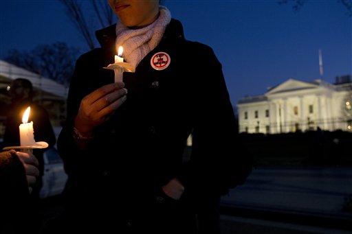 Lindsay Merikas, 26, of Alexandria, Va., wears a button saying "Stop Gun Violence" as she gathers with other supporters of gun control on Pennsylvania Avenue in front of the White House, in Washington, Friday, Dec. 14, 2012, during a vigil for the victims of the shooting at Sandy Hook Elementary School in Newtown, Ct., and to call on President Obama to pass strong gun control laws. (AP Photo/Jacquelyn Martin)