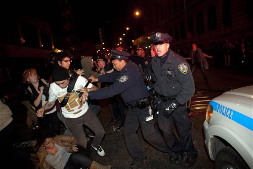 Occupy Wall Street protesters clash with police near Zuccotti Park after being ordered to leave their longtime encampment in New York, early Tuesday, Nov. 15, 2011. At about 1 a.m. Tuesday, police handed out notices from the park's owner, Brookfield Office Properties, and the city saying that the park had to be cleared because it had become unsanitary and hazardous. Protesters were told they could return, but without sleeping bags, tarps or tents. (AP Photo/John Minchillo)