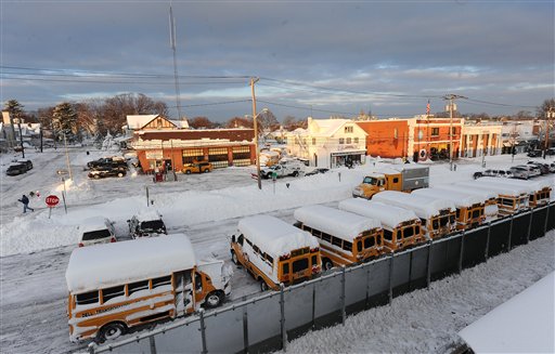 School buses covered with snow are lined up in Port Washington as snow covered areas throughout Long Island on Thursday, Jan. 27, 2011, in New York.  Many local school districts closed schools for the day. (AP Photo/Kathy Kmonicek)