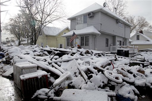 A pile of garbage in the street is covered with snow in the New Dorp section of Staten Island, N.Y.,  Thursday, Nov. 8, 2012.  The New York-New Jersey region woke up to a layer of wet snow and more power outages after a new storm pushed back efforts to recover from Superstorm Sandy.  (AP Photo/Seth Wenig)